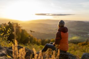 Frau blickt auf Berge bei Sonnenuntergang